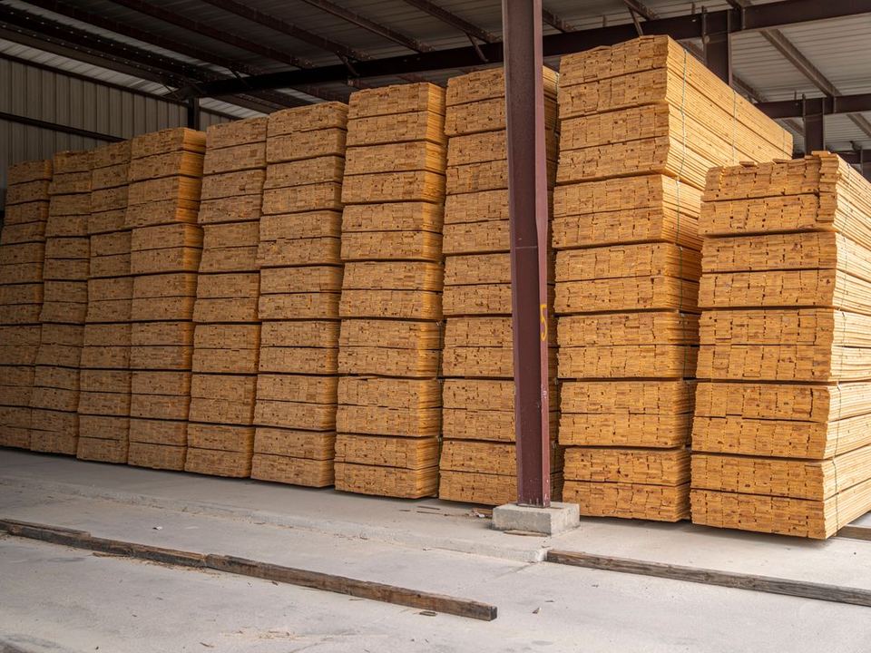 Paquetes de madera elaborada apilados bajo techo