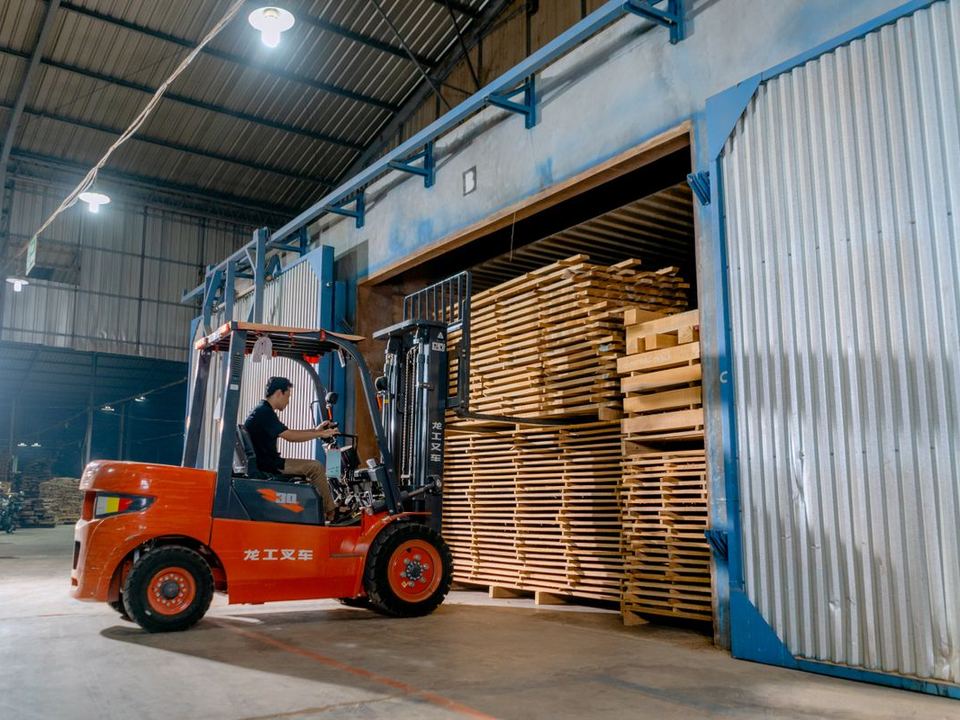 Grúa horquilla entrando paquetes de madera a una cámara de secado